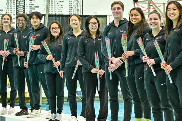 Members of the MIT Swim and Dive team holding roses